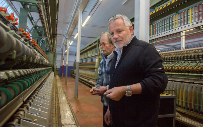 Christian Didier (au premier plan), le directeur d'Emanuel Lang à côté de Thierry Guth (au second plan), responsable de l'atelier de filature de lin devant les machines à tisser le lin importées de Hongrie.