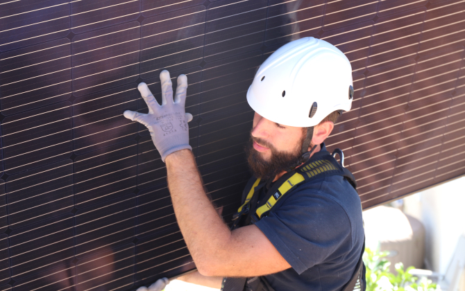 Un technicien d'A+Energies installe des panneaux photovoltaïques