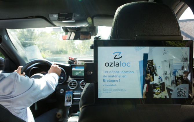 Com Cars propose des spots publicitaires diffusés sur des écrans de tablette dans les taxis rennais, nantais, et bientôt ailleurs en France.
