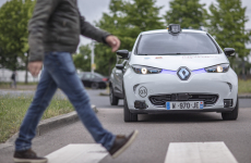 Un piéton traverse la rue devant une Renault Zoe électrique et autonome, mise en circulation dans le cadre du projet "Rouen Normandy Autonomous Lab".