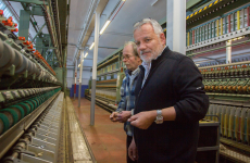 Christian Didier (au premier plan), le directeur d'Emanuel Lang à côté de Thierry Guth (au second plan), responsable de l'atelier de filature de lin devant les machines à tisser le lin importées de Hongrie.