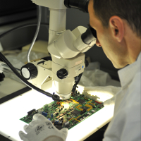 Composants électroniques sous un microscope fabriqués sur le site d'Eolane en Ardèche.