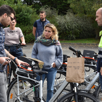 Jean-Charles Bougro (à dr), responsable de la plateforme logistique MerAlliance de Landivisiau, écoute les explications concernant un vélo électrique.